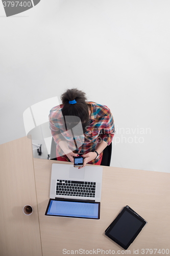 Image of top view of young business woman working on laptop