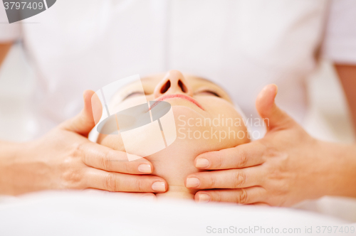 Image of Woman under facial treatment at beauty spa