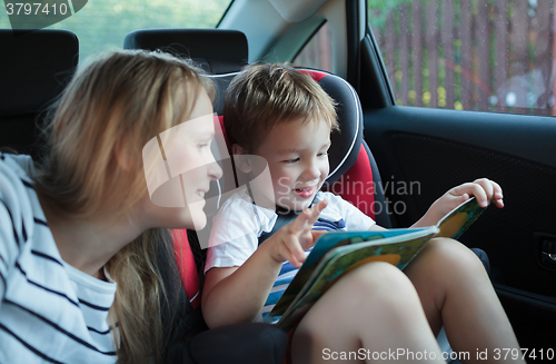 Image of Mother and son with a book in the car