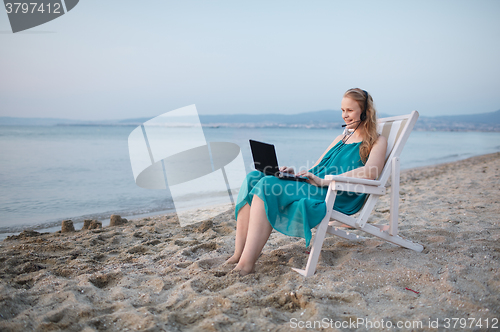 Image of Woman talking skype at the beach