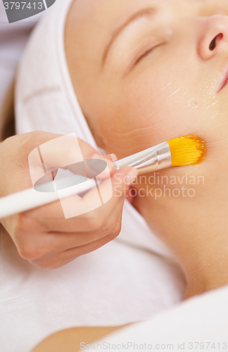 Image of Woman being applied a facial mask