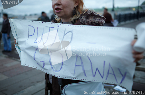 Image of Woman holds a placard Putin Go Away.