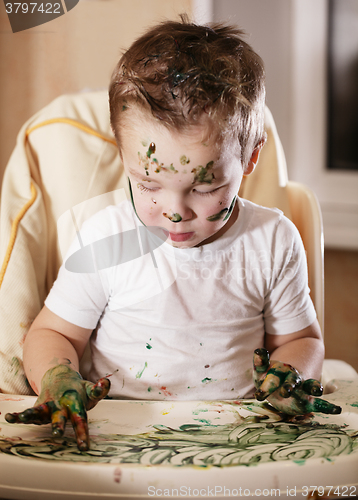 Image of Creative little boy playing with finger paint