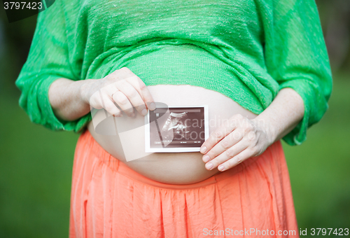 Image of Pregnant woman with ultrasound image of a baby