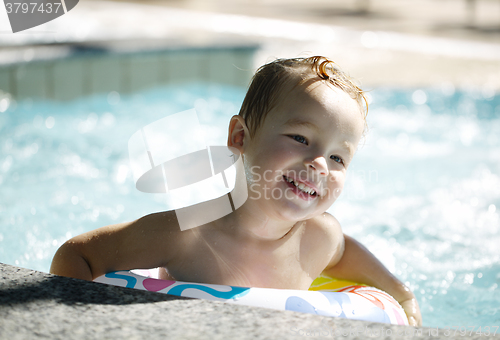 Image of Kid learns to swim using a plastic water ring