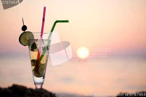 Image of Mojito cocktail on the beach at sunset