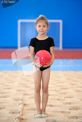 Image of Little gymnast girl with red ball