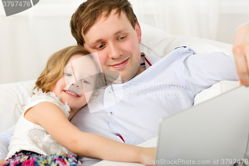 Image of Happy dad and daughter with laptop