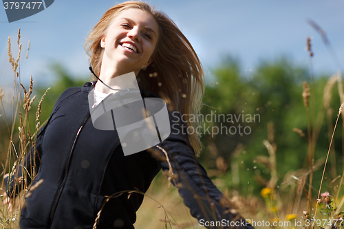 Image of Young happy girl running in the field