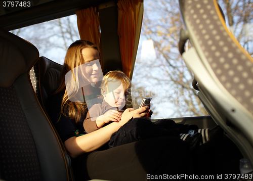 Image of Mother and kid are playing game on the phone.