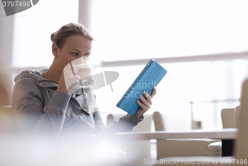 Image of Woman in cafe using her touchpad