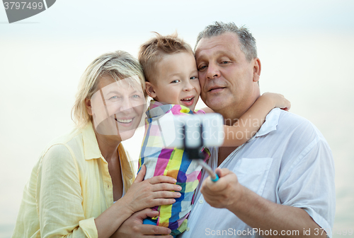 Image of Grandparents and grandson making phone selfie