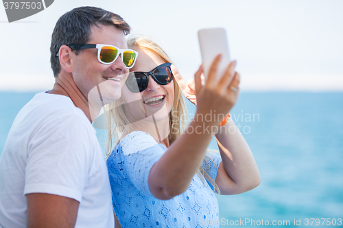 Image of Happy summer selfie of young couple in sunglasses