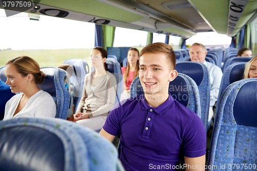 Image of happy young man sitting in travel bus or train