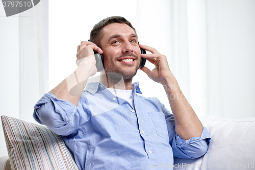 Image of smiling young man in headphones at home