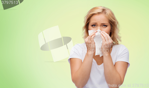 Image of unhappy woman with paper napkin blowing nose