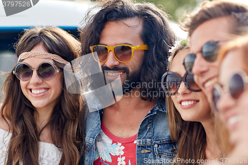 Image of smiling young hippie friends over minivan car