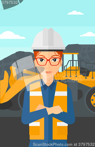 Image of Miner with mining equipment on background.