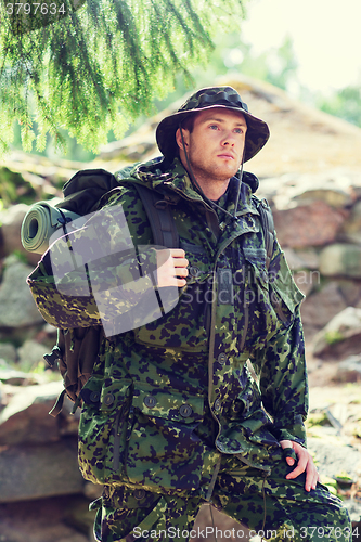 Image of young soldier with backpack in forest