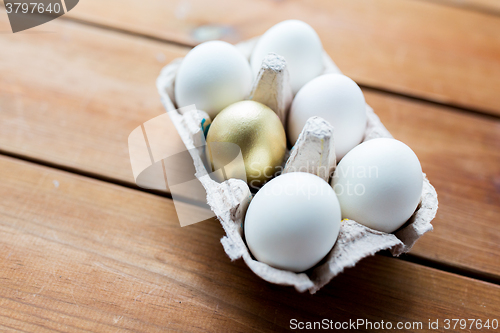 Image of close up of white and gold eggs in egg box