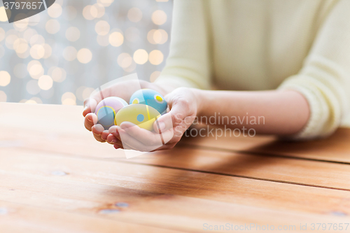 Image of close up of woman hands with colored easter eggs