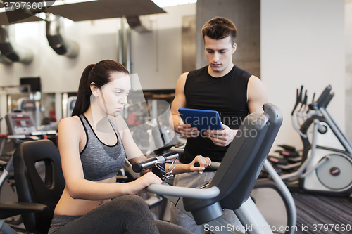 Image of woman with trainer on exercise bike in gym