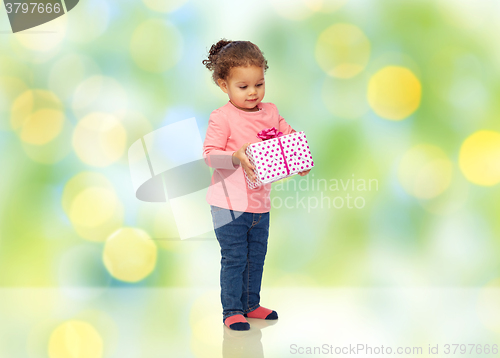 Image of beautiful little baby girl with birthday present