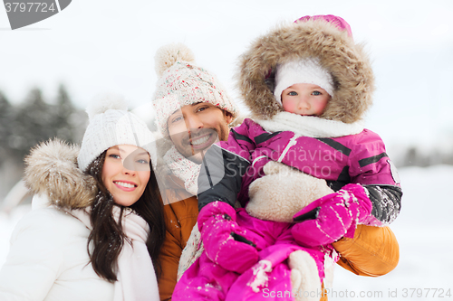 Image of happy family with child in winter clothes outdoors