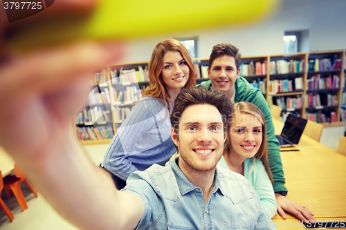 Image of students with smartphone taking selfie in library