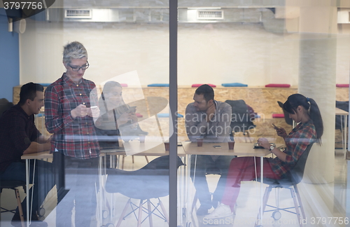 Image of business woman in meeting room  speaking by cell phone