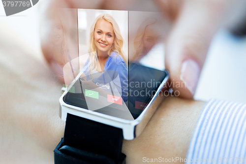 Image of close up of hand with incoming call on smart watch