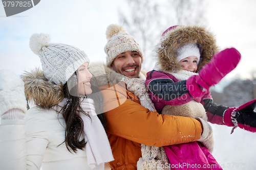 Image of happy family with child in winter clothes outdoors