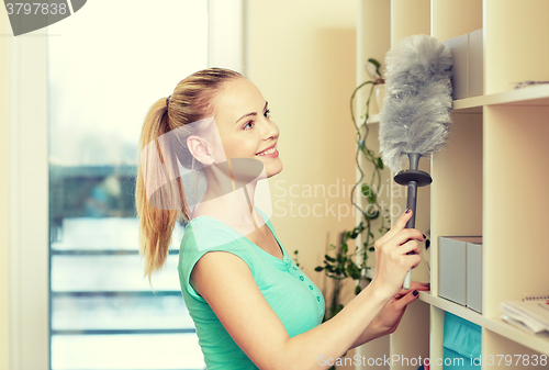 Image of happy woman with duster cleaning at home