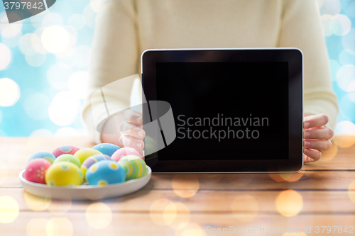 Image of close up of woman with tablet pc and easter eggs