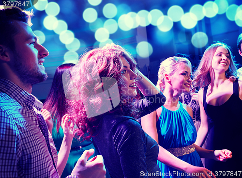 Image of smiling friends dancing in club