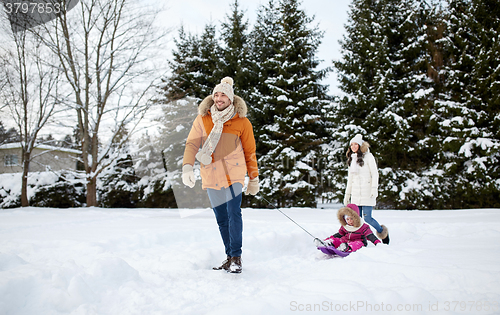 Image of happy family with sled walking in winter outdoors