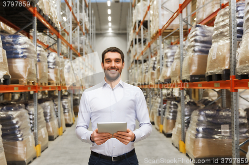 Image of happy businessman with tablet pc at warehouse