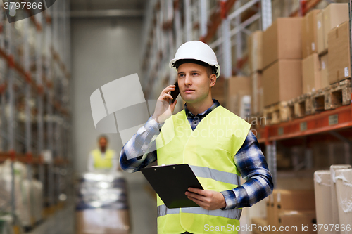 Image of man with clipboard and smartphone at warehouse
