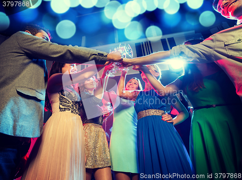 Image of smiling friends with glasses of champagne in club