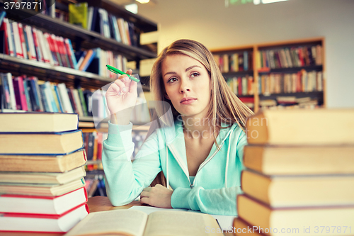 Image of bored student or young woman with books in library