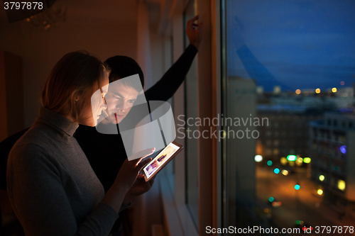 Image of Couple with pad at home in the evening