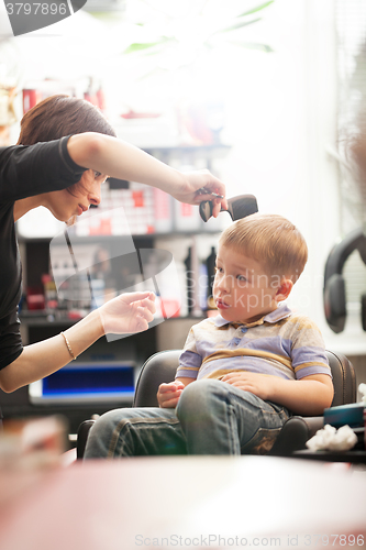 Image of Little boy having a hair cut in salon