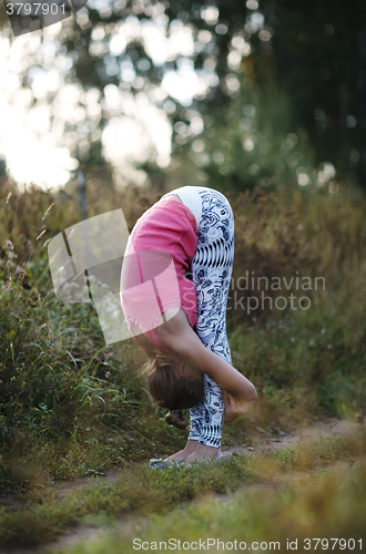 Image of Supple young woman bending double