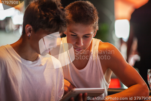 Image of Teenagers watching something on touch pad