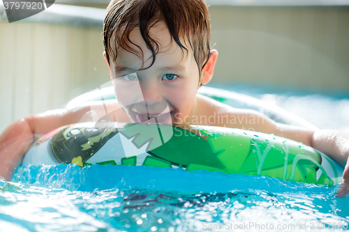 Image of Boy in inflatable ring having fun