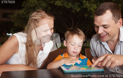 Image of Family of three spending time in cafe with tablet computer