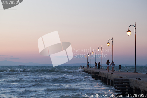 Image of People walking along the pier in evening