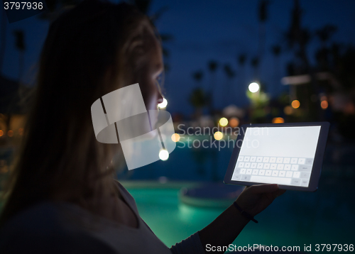 Image of Woman tourist with pad on tropical resort in late evening