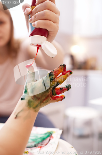 Image of Young child playing with finger paints