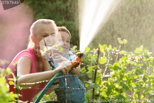 Image of Mother and son playing with water